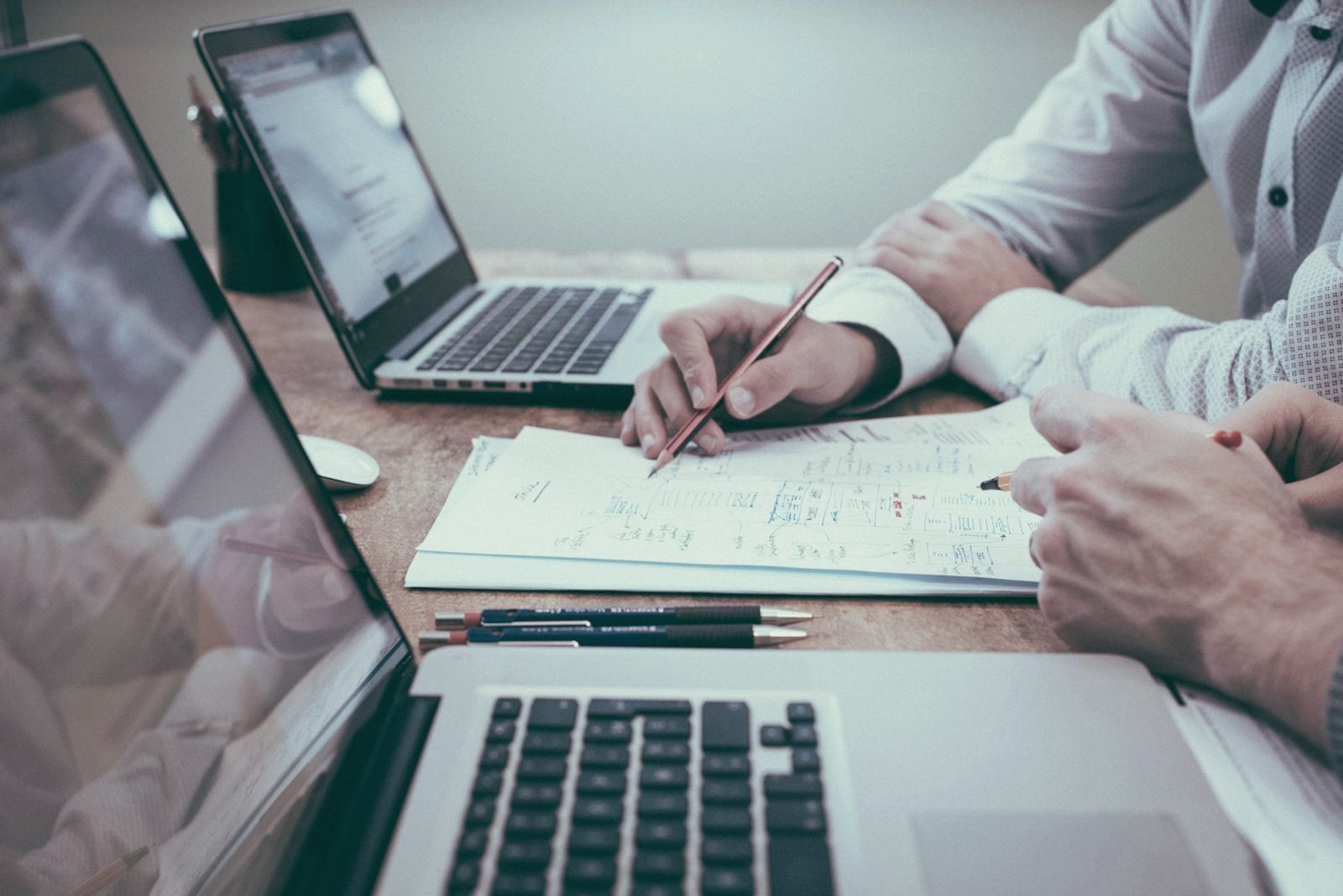 Two people reviewing notes and plans together at a desk