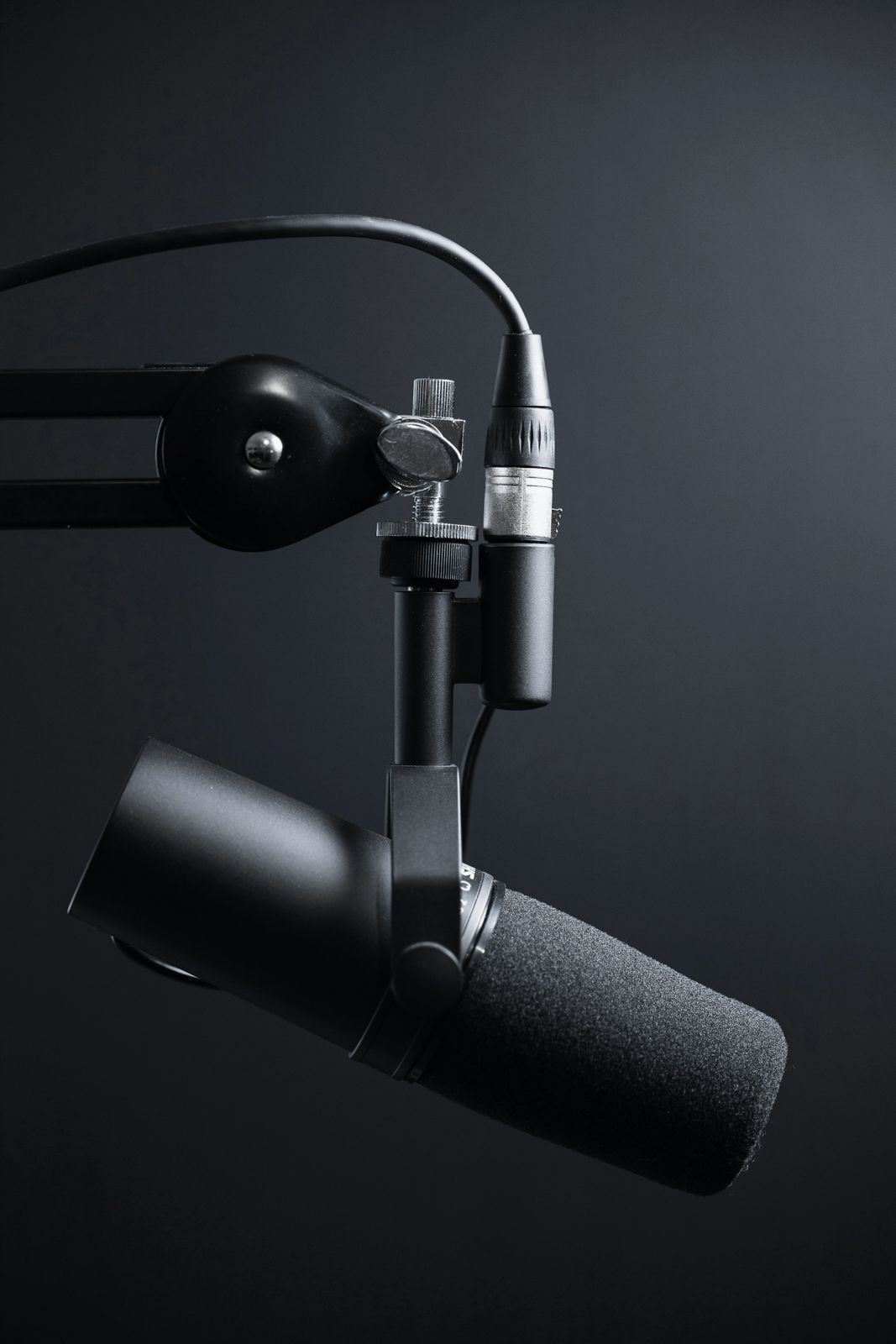 A broadcast microphone on a boom arm