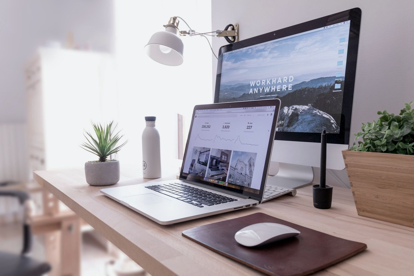 A tidy desk with a laptop and monitor showing a website